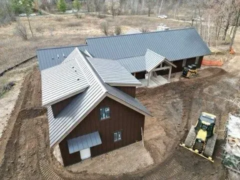 An aerial view of a house under construction in a dirt field.