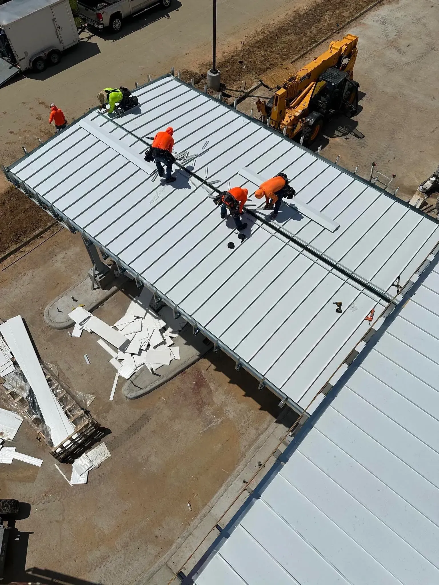 A group of construction workers are working on the roof of a building.