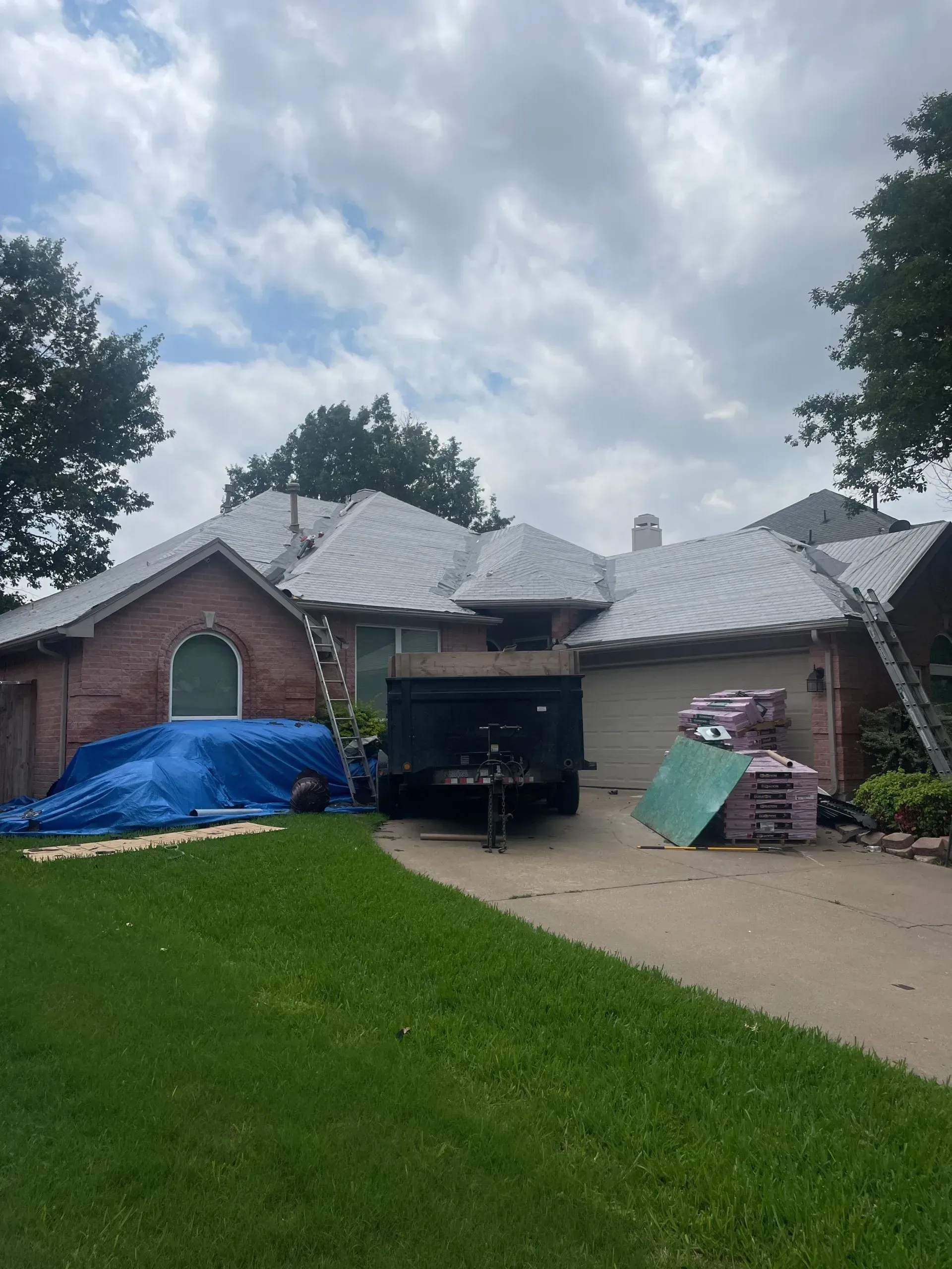 A brick house with a white roof is being remodeled.