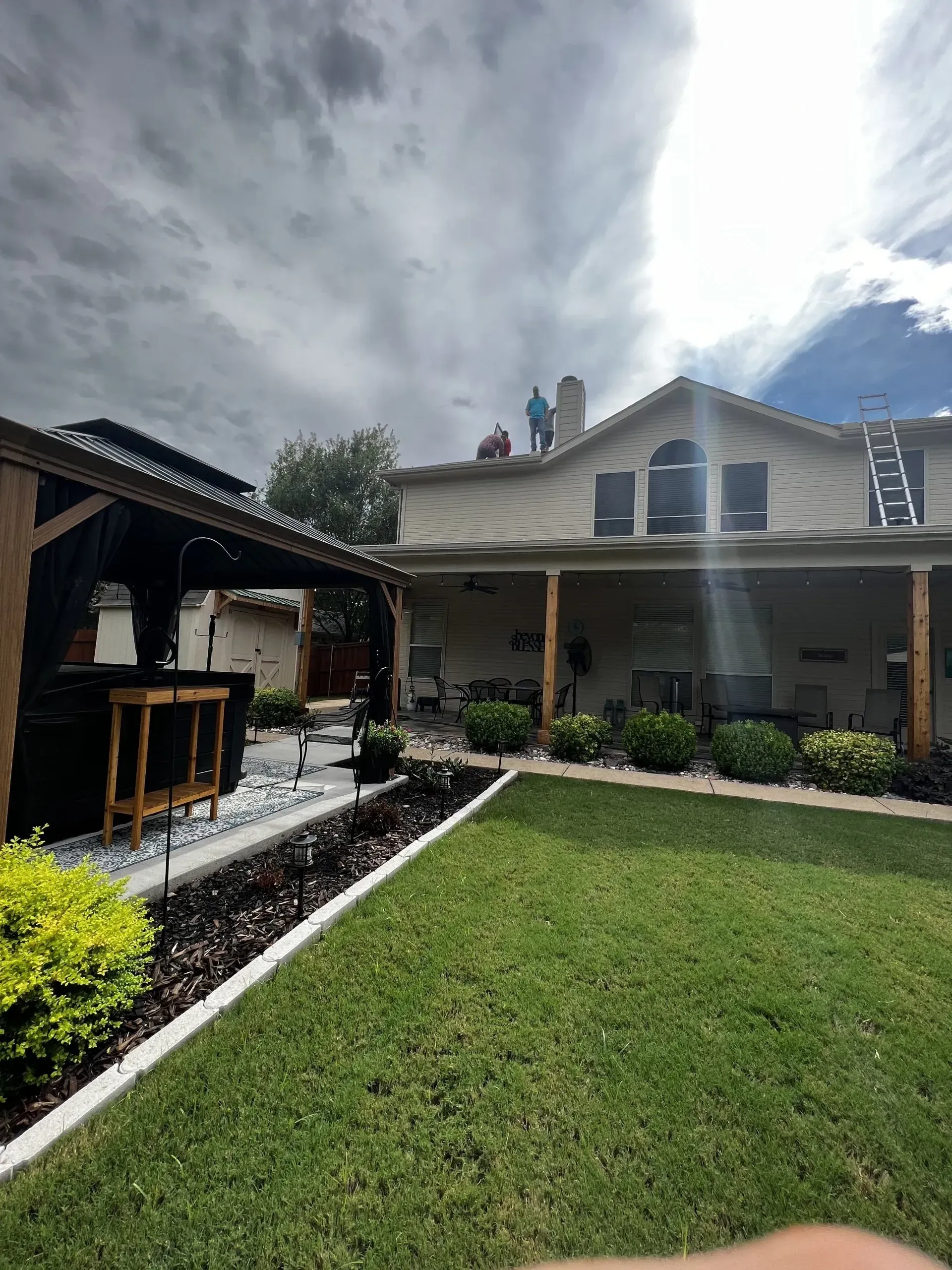 A man is standing on the roof of a house.