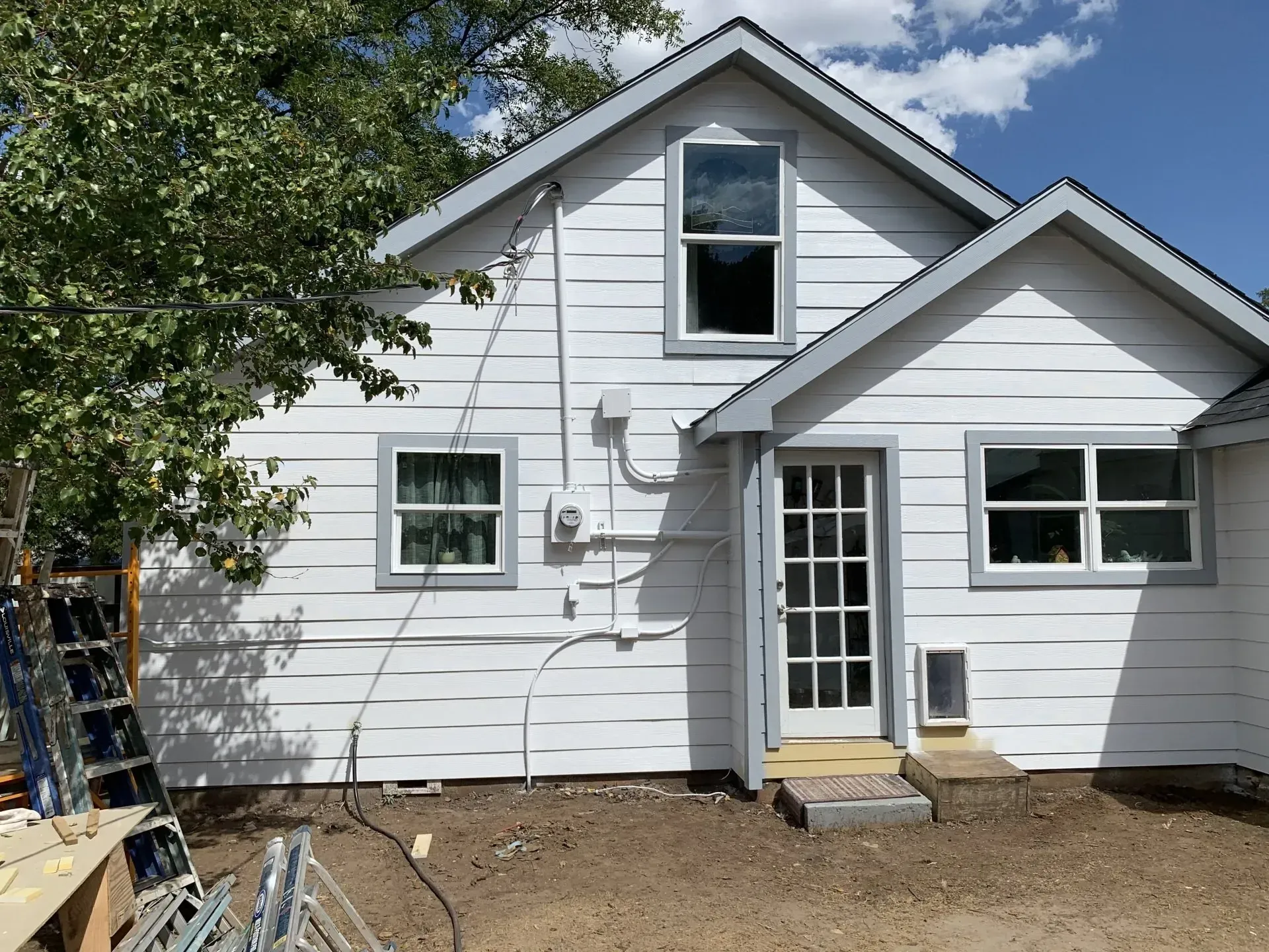 A white house with a ladder in front of it