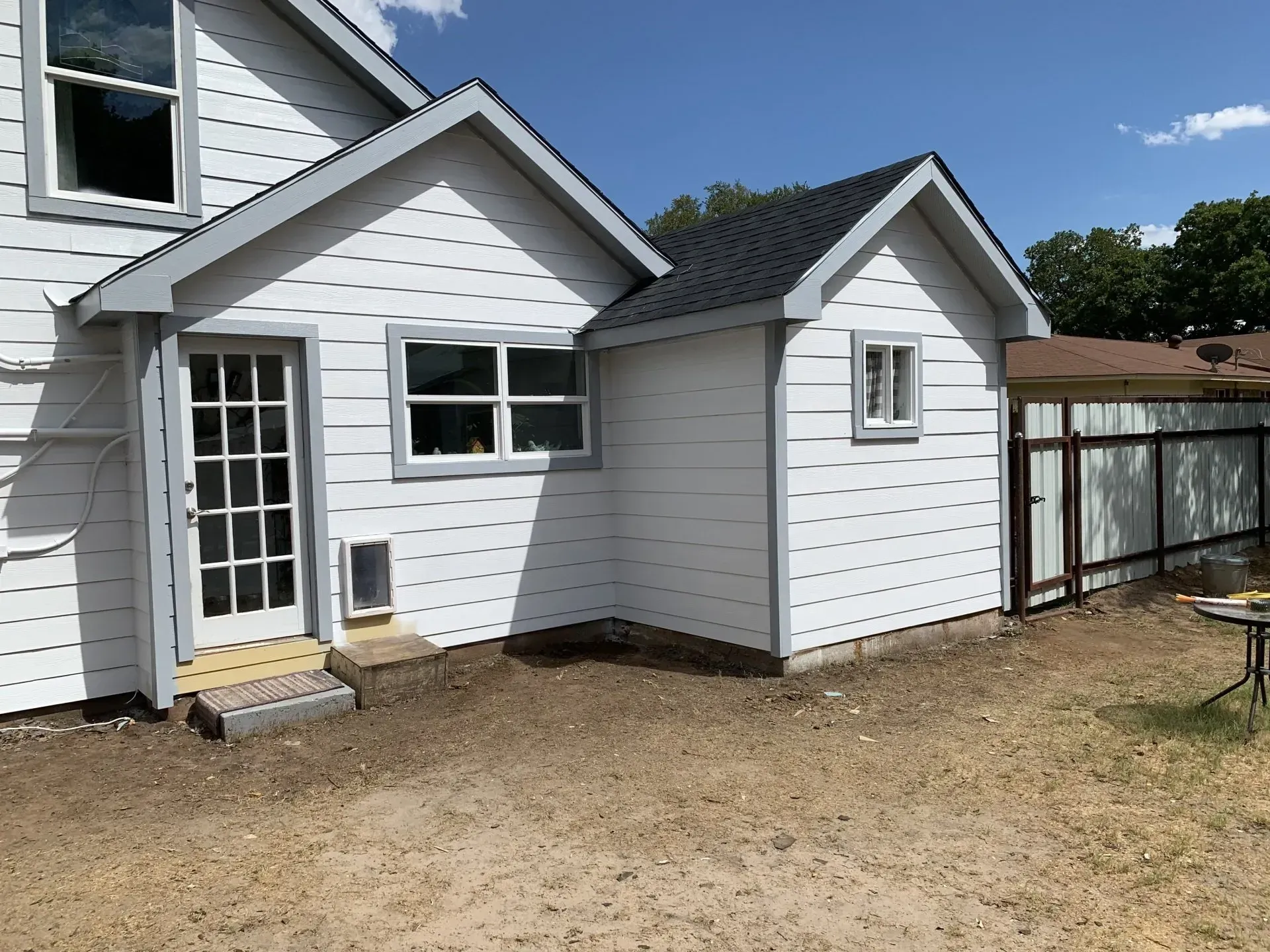 A white house with a shed in the backyard