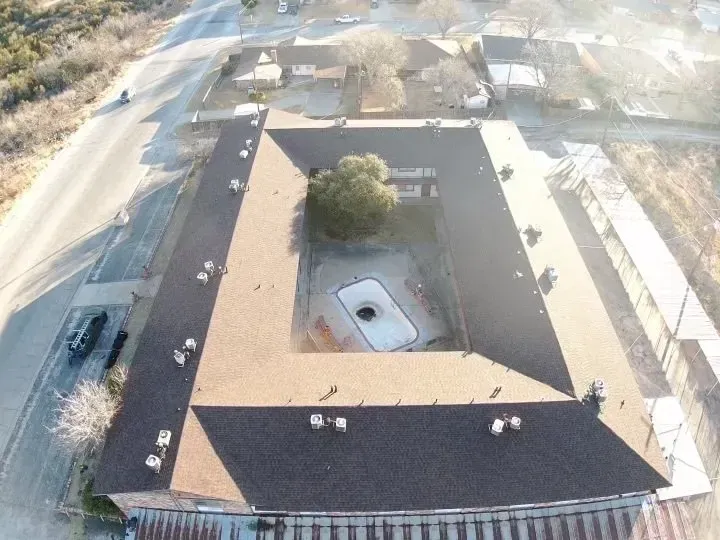 An aerial view of a large building with a tree in the middle
