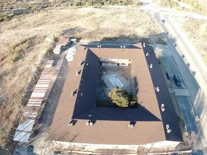 An aerial view of a building with a pool in the middle