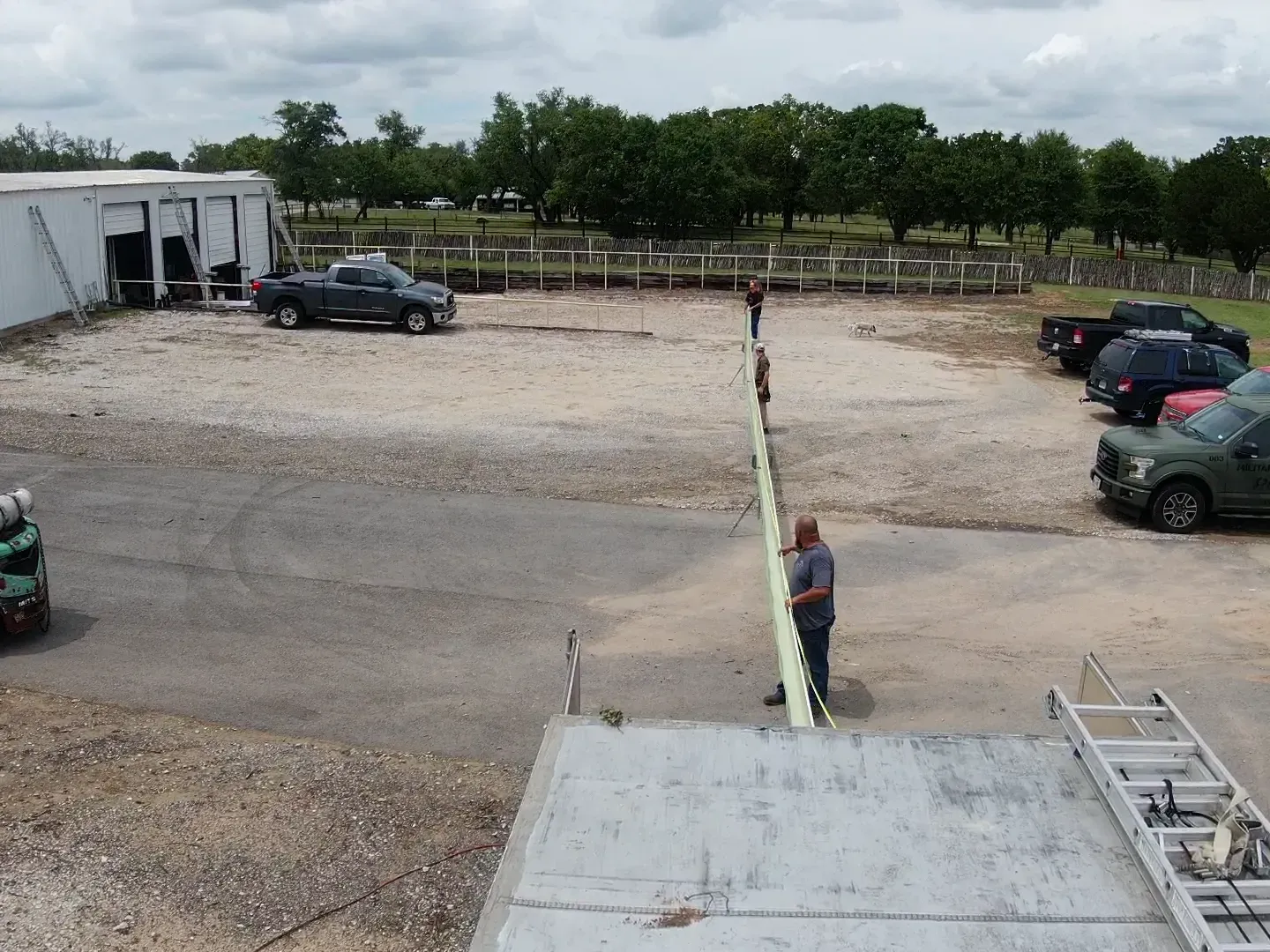 A man is standing next to a fence in a parking lot