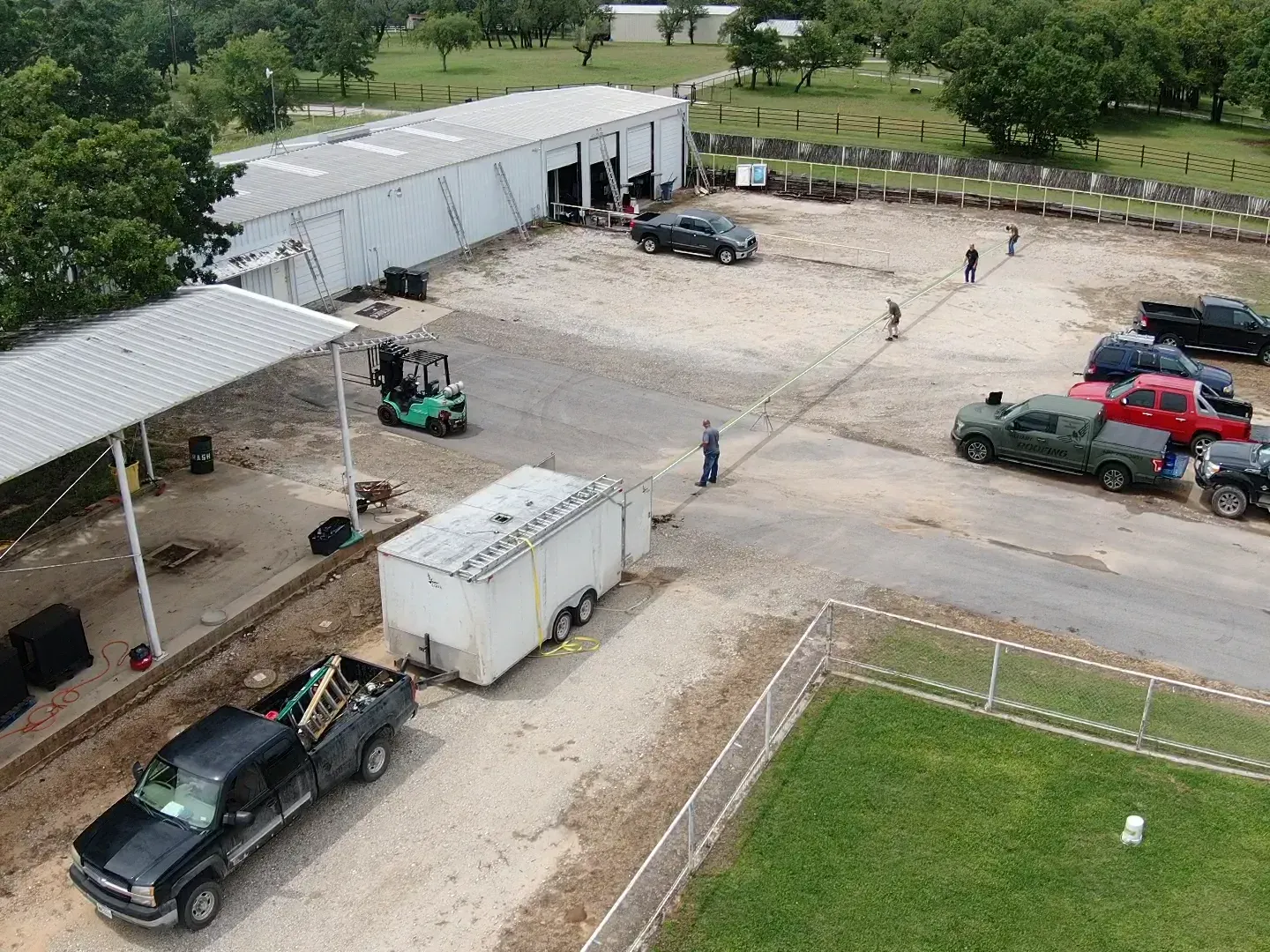 An aerial view of a parking lot with trucks and trailers parked in front of a building.