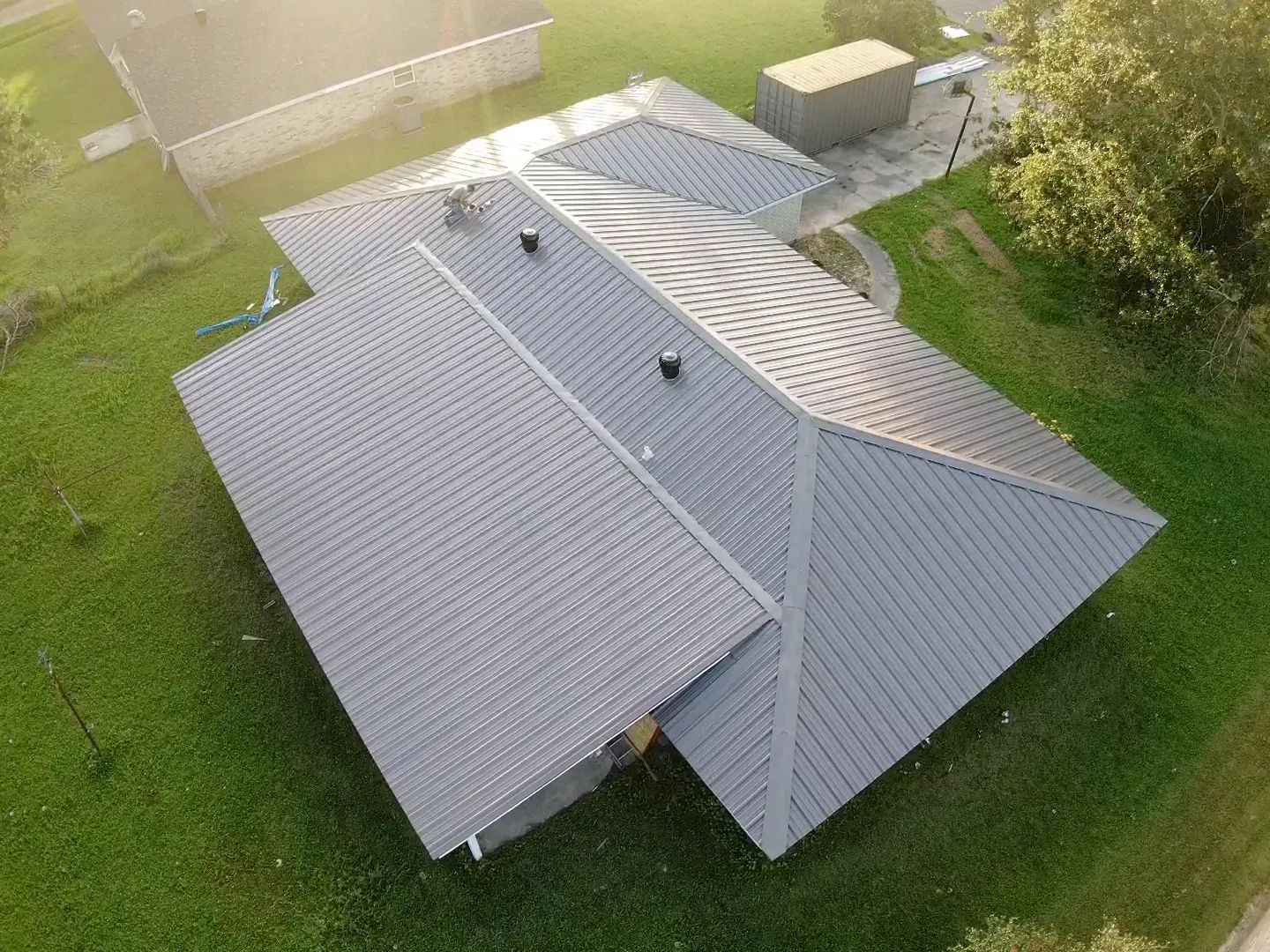 An aerial view of a house with a gray metal roof.
