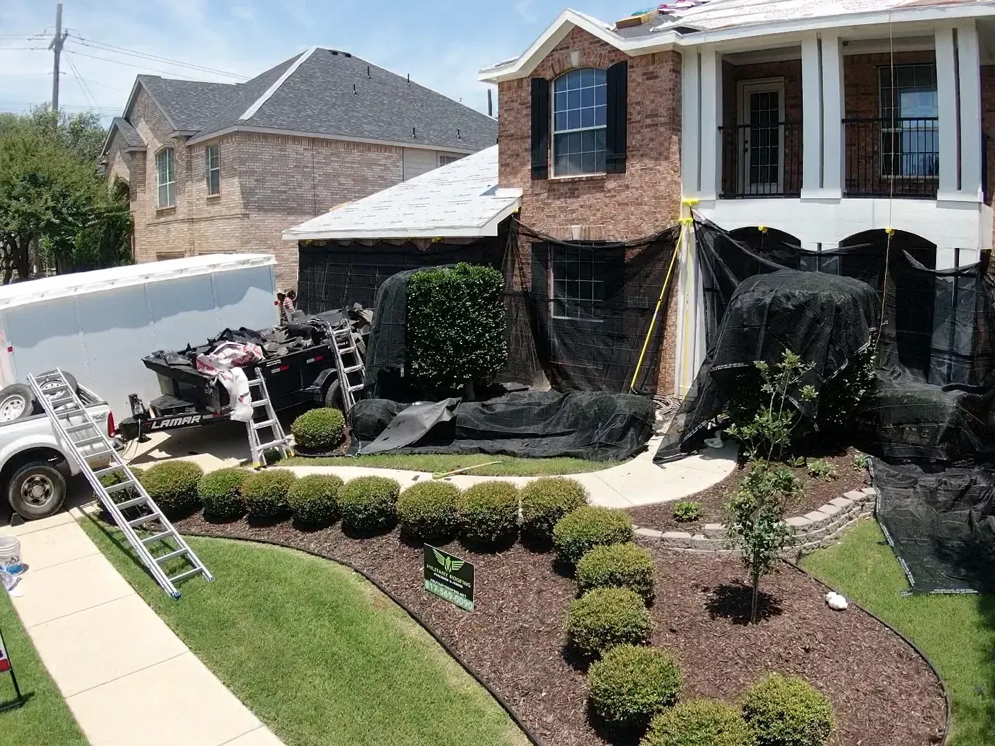 A house is being painted with a truck parked in front of it.