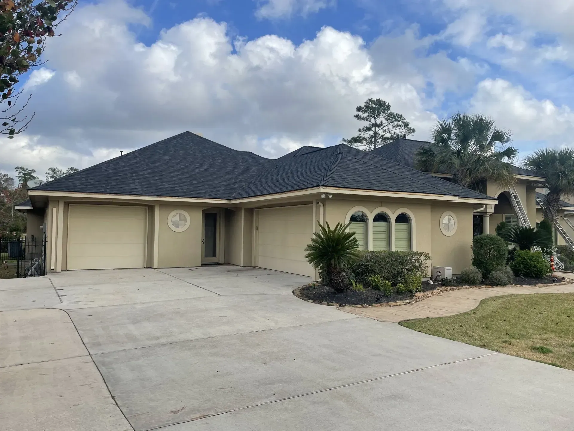 A large house with a gray roof and a driveway.