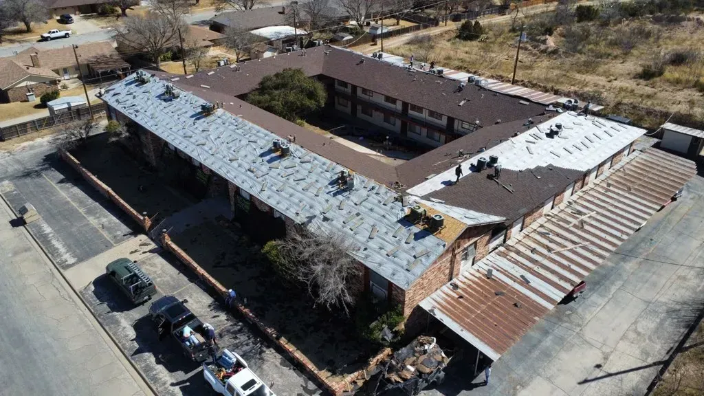 An aerial view of a large building with a lot of cars parked in front of it.