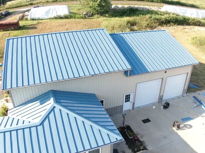 An aerial view of a house with a blue metal roof.