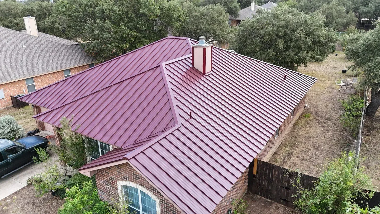 An aerial view of a house with a purple metal roof.
