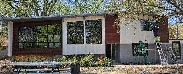A modern house with a lot of windows is being built.