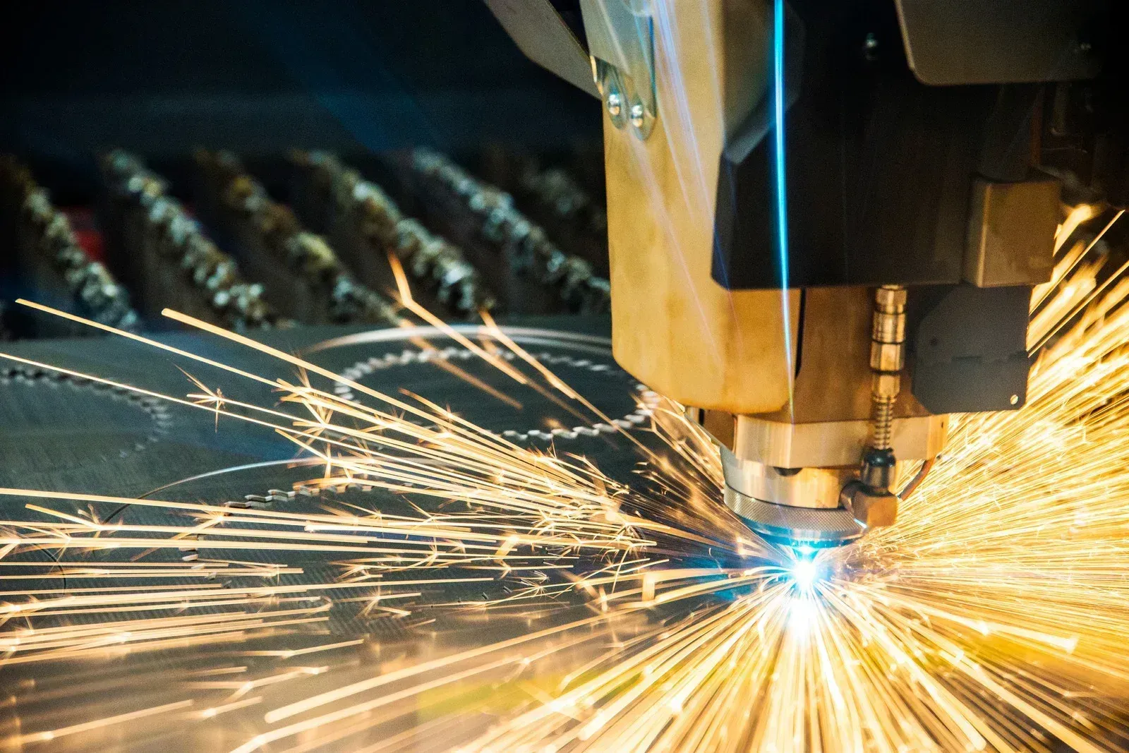 A machine is cutting a piece of metal with sparks coming out of it.
