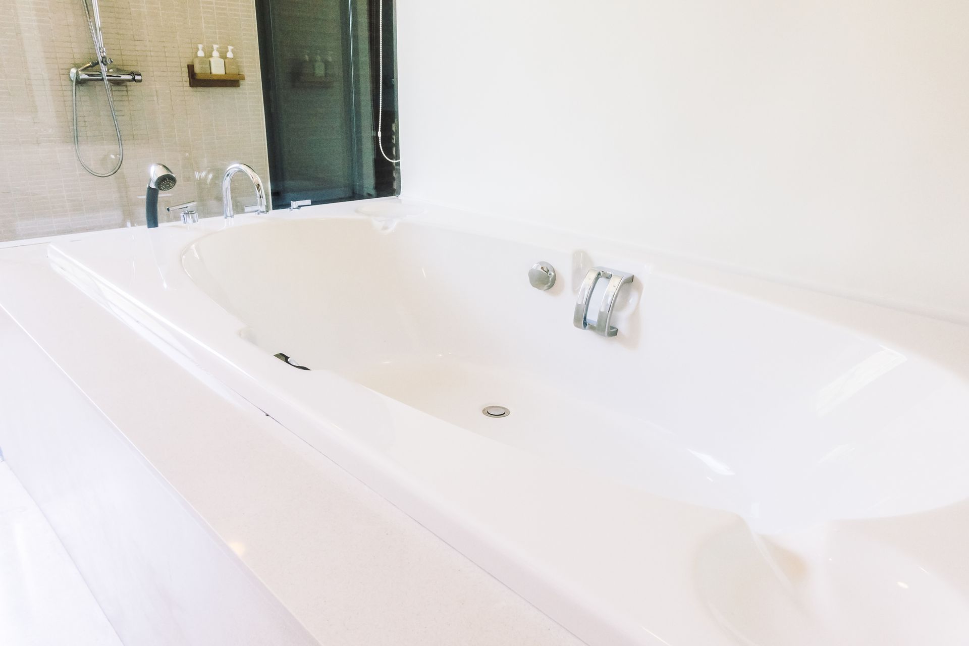 A white bathtub in a bathroom next to a shower.