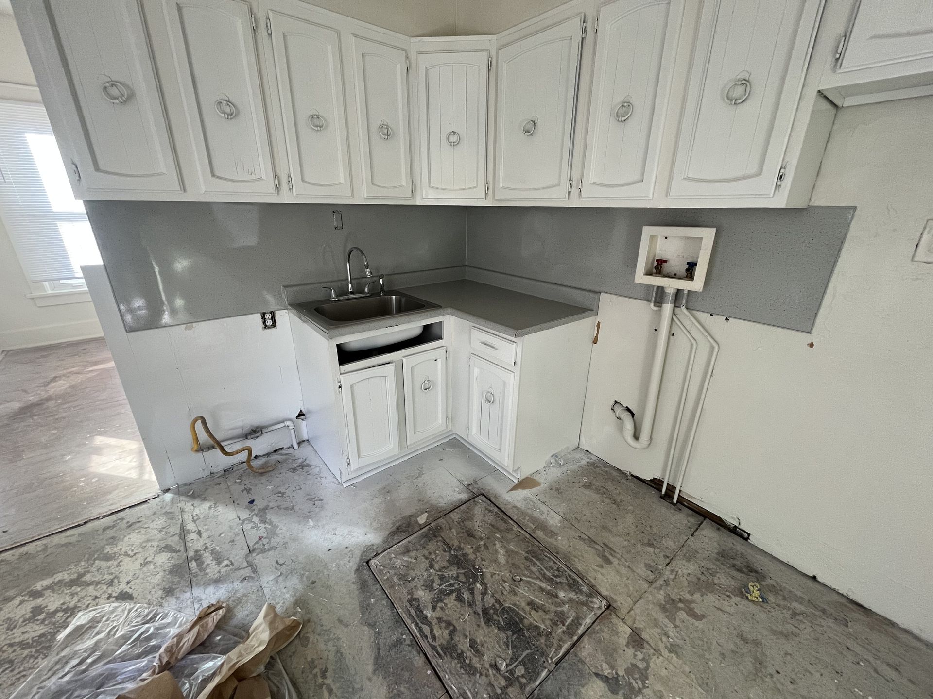 A kitchen with a lot of cabinets and shelves covered in plastic