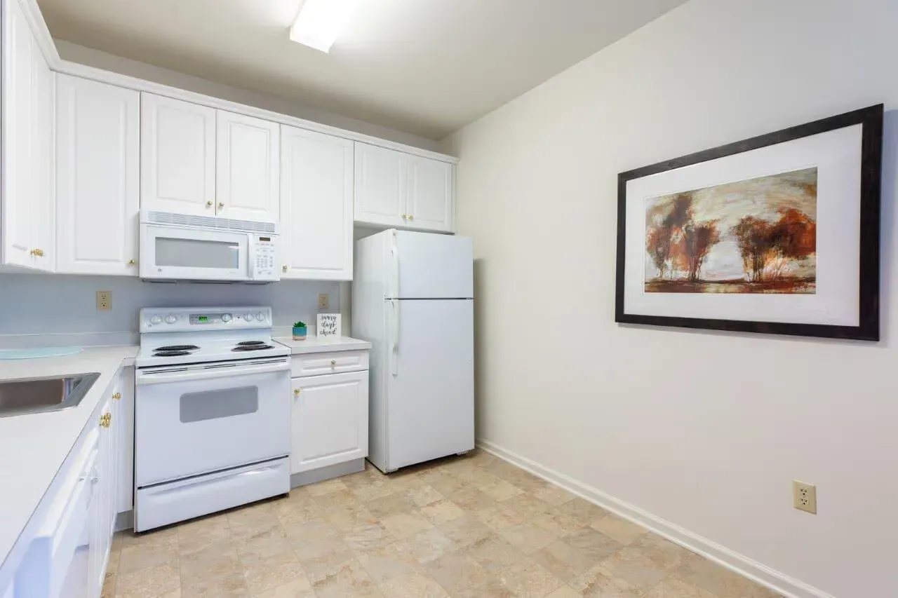 White apartment kitchen with cabinets, stove, microwave, and refrigerator. Visit us at Fox Ridge Apartments and view our pet-friendly apartments for rent in Limerick, PA.