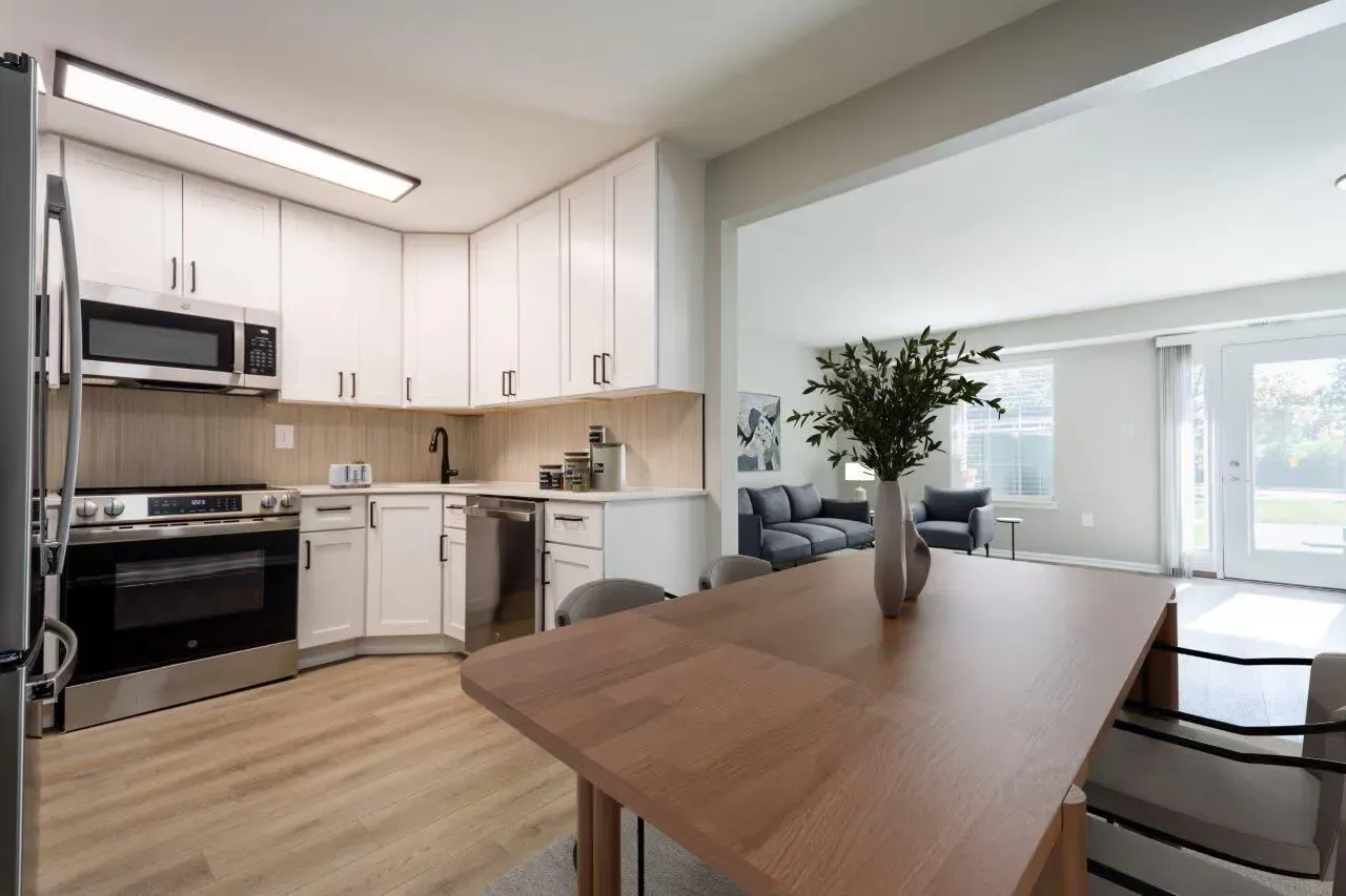 Open-concept kitchen with white cabinets and stainless-steel appliances opening to a living area. Visit us at Fox Ridge Apartments and view our pet-friendly apartments for rent in Limerick, PA.