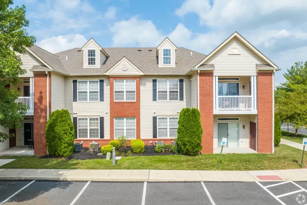 Exterior view of a two-story apartment building with brick accents and well-maintained landscaping. Visit us at Fox Ridge Apartments and view our modern, garden-style 1 and 2 bedroom apartments in Limerick, PA.
