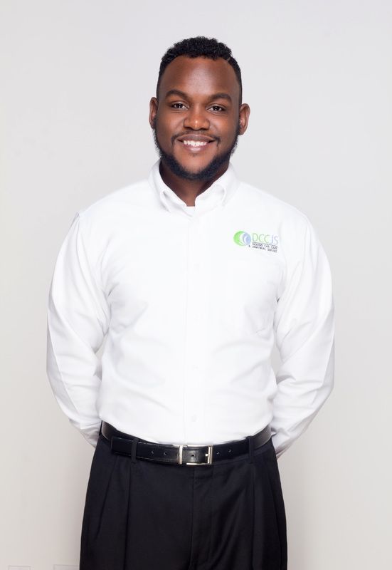 A man wearing a white shirt and black pants is smiling