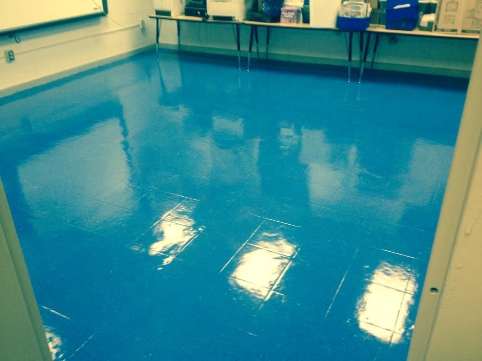 A room with a blue floor and a white board on the wall