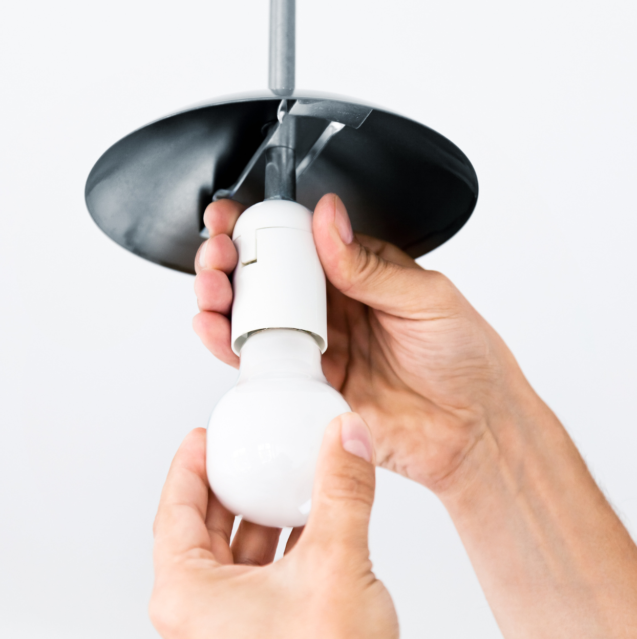 A person wearing pink gloves is cleaning a window sill.