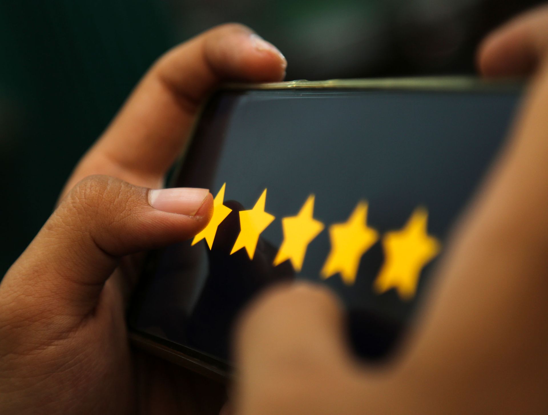 Attractive Hands Showing Five Stars Rating On A Smart Phone — Green Bay, WI — Brabazon Law Office LLC