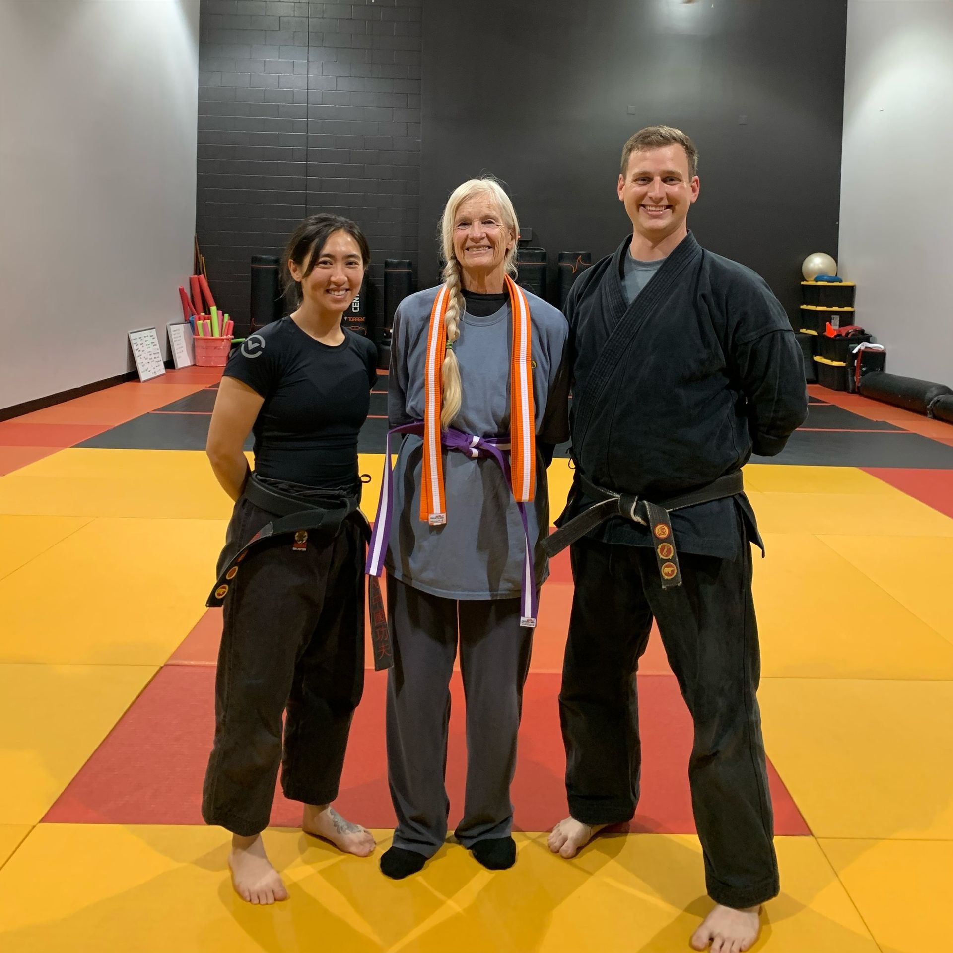 Three people are posing for a picture in a gym.