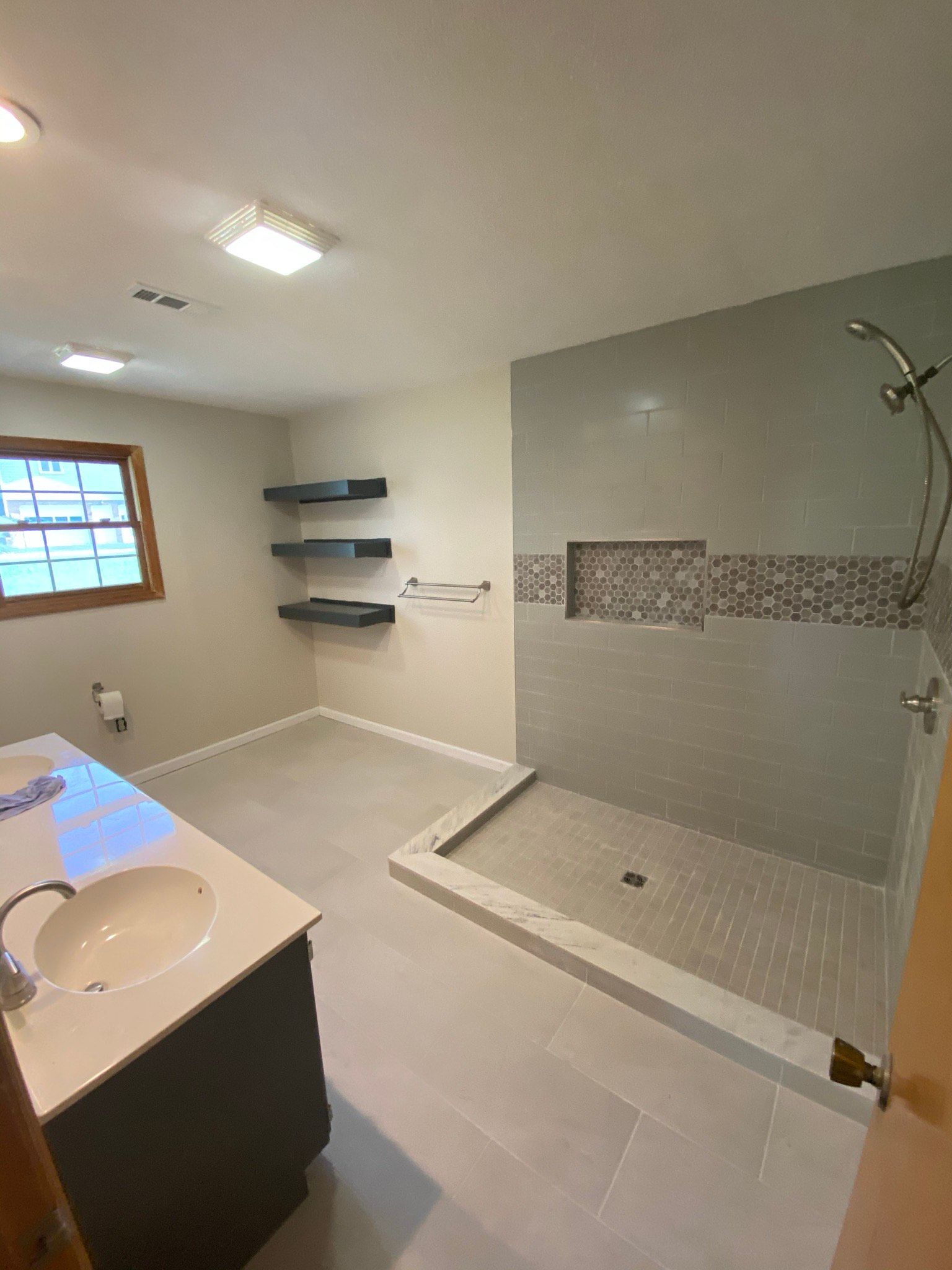 A bathroom with a sink and a walk in shower.