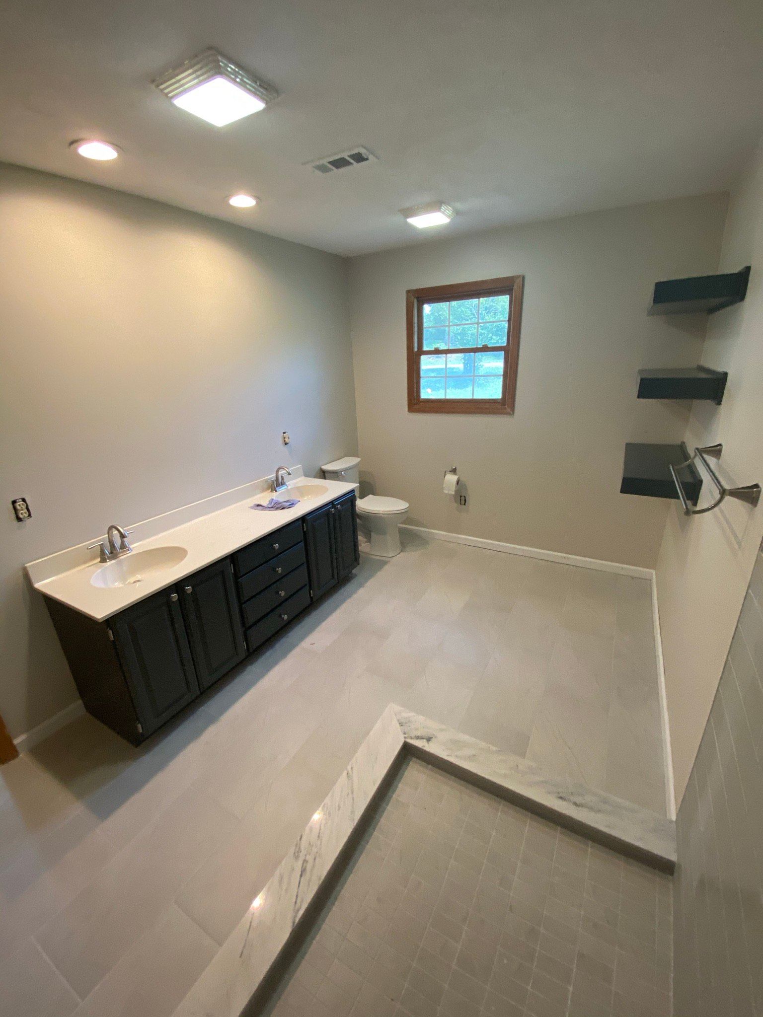A bathroom with a sink , toilet , and window.