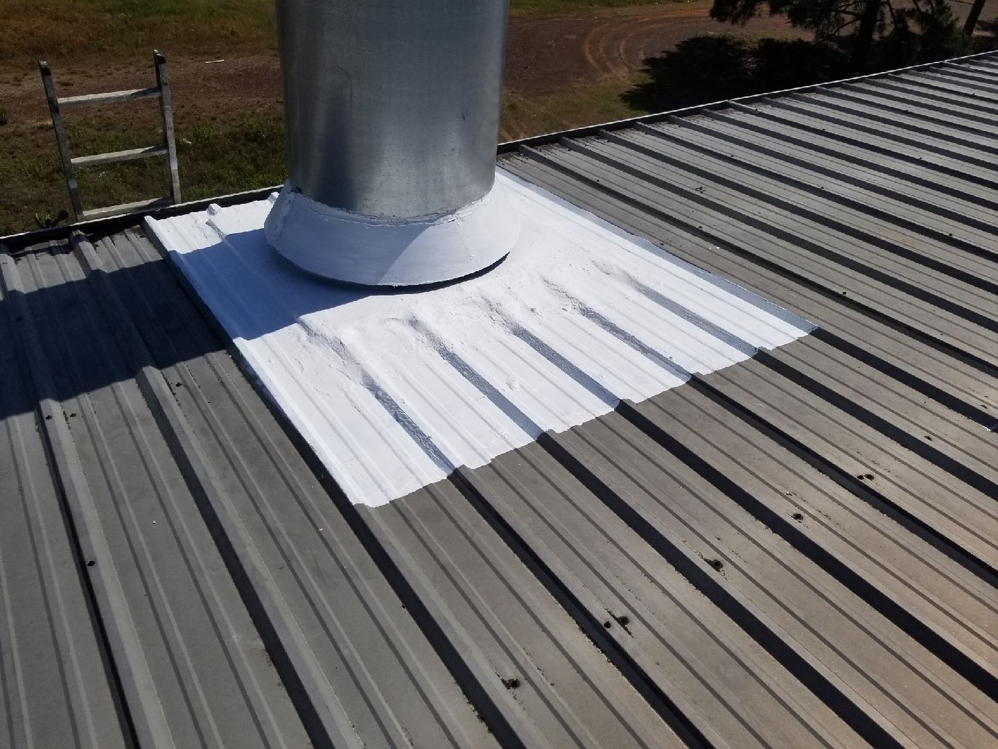 A metal roof with a chimney on top of it