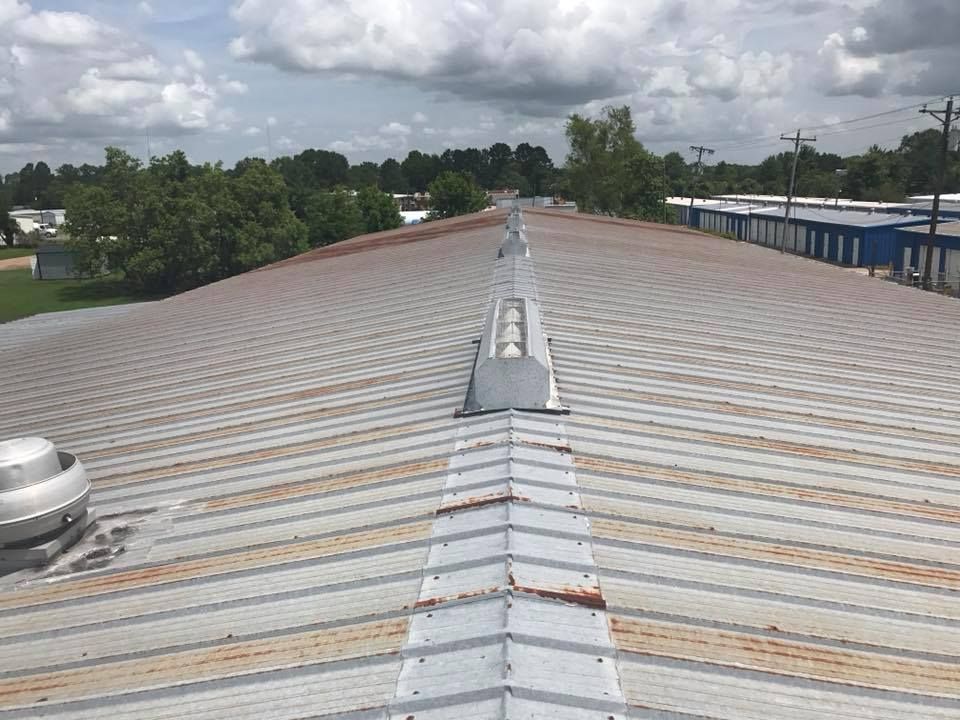 The roof of a building with a lot of trees in the background.