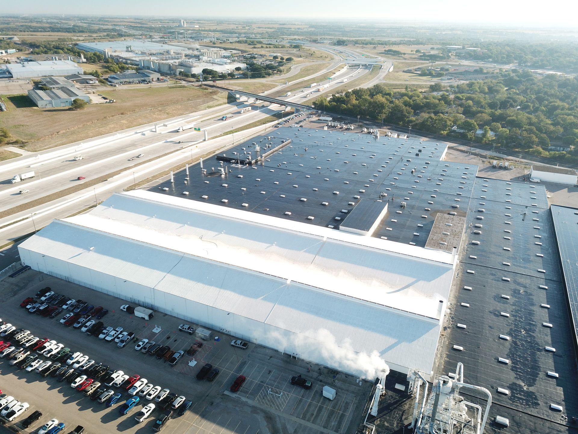 An aerial view of a large building with a parking lot in front of it.