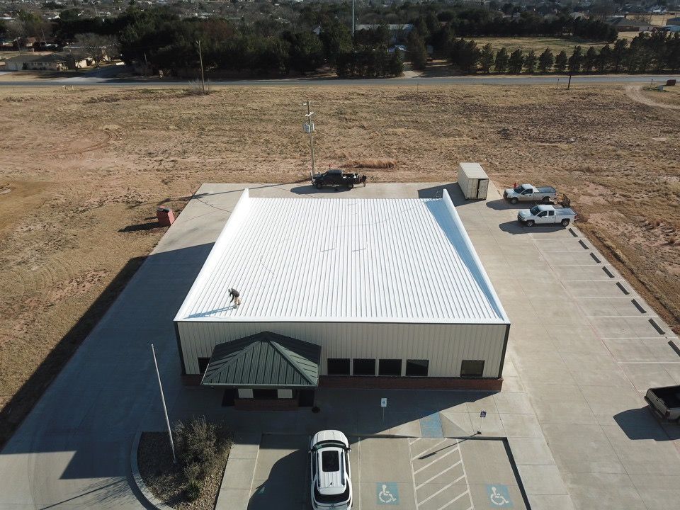 An aerial view of a building with a white roof