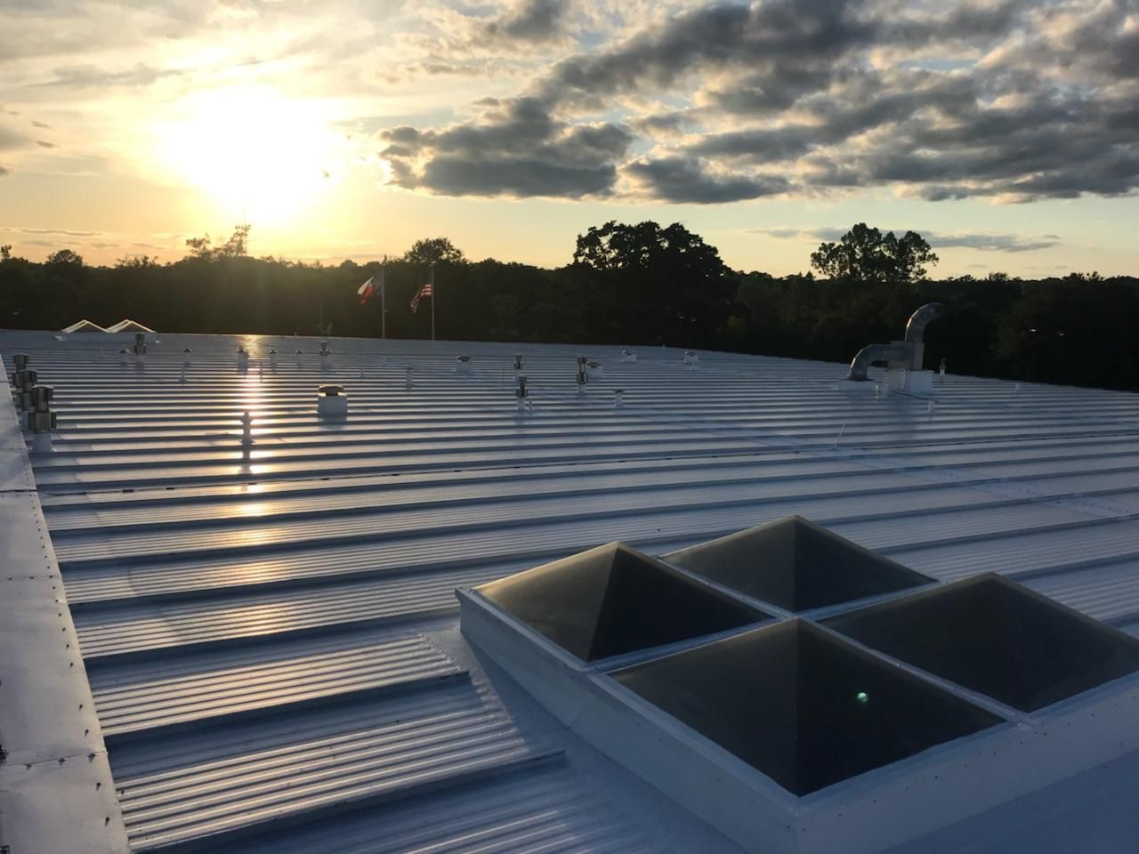 The sun is shining through the clouds on the roof of a building.