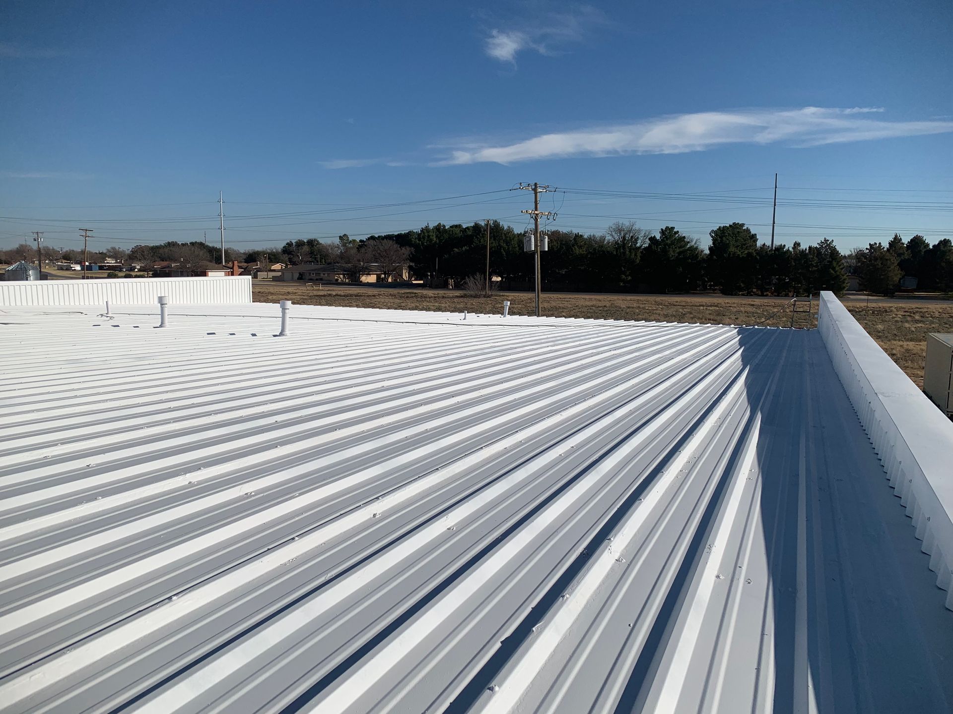 A white metal roof with a blue sky in the background