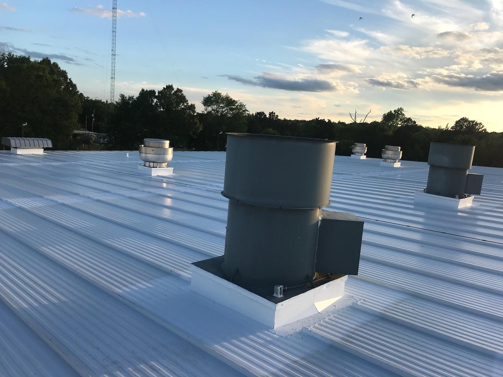 A white roof with a lot of vents on it