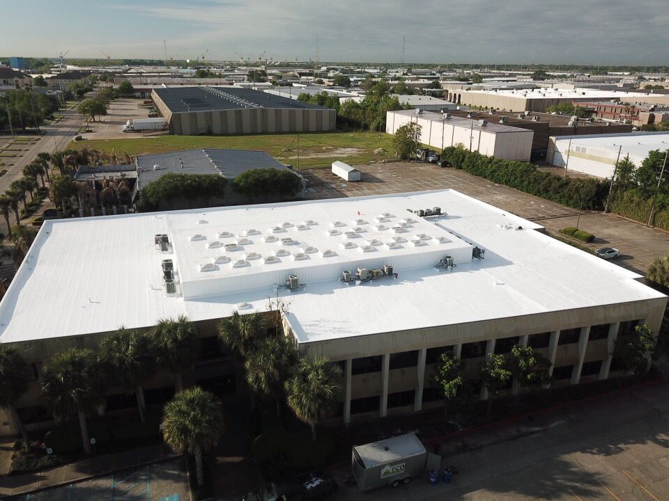 An aerial view of a large building with a white roof.