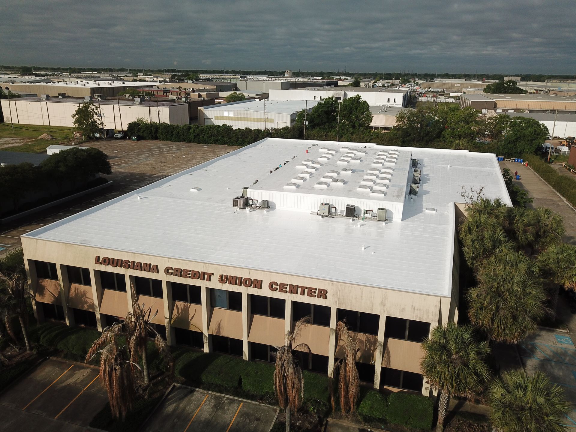 An aerial view of a large building with a white roof