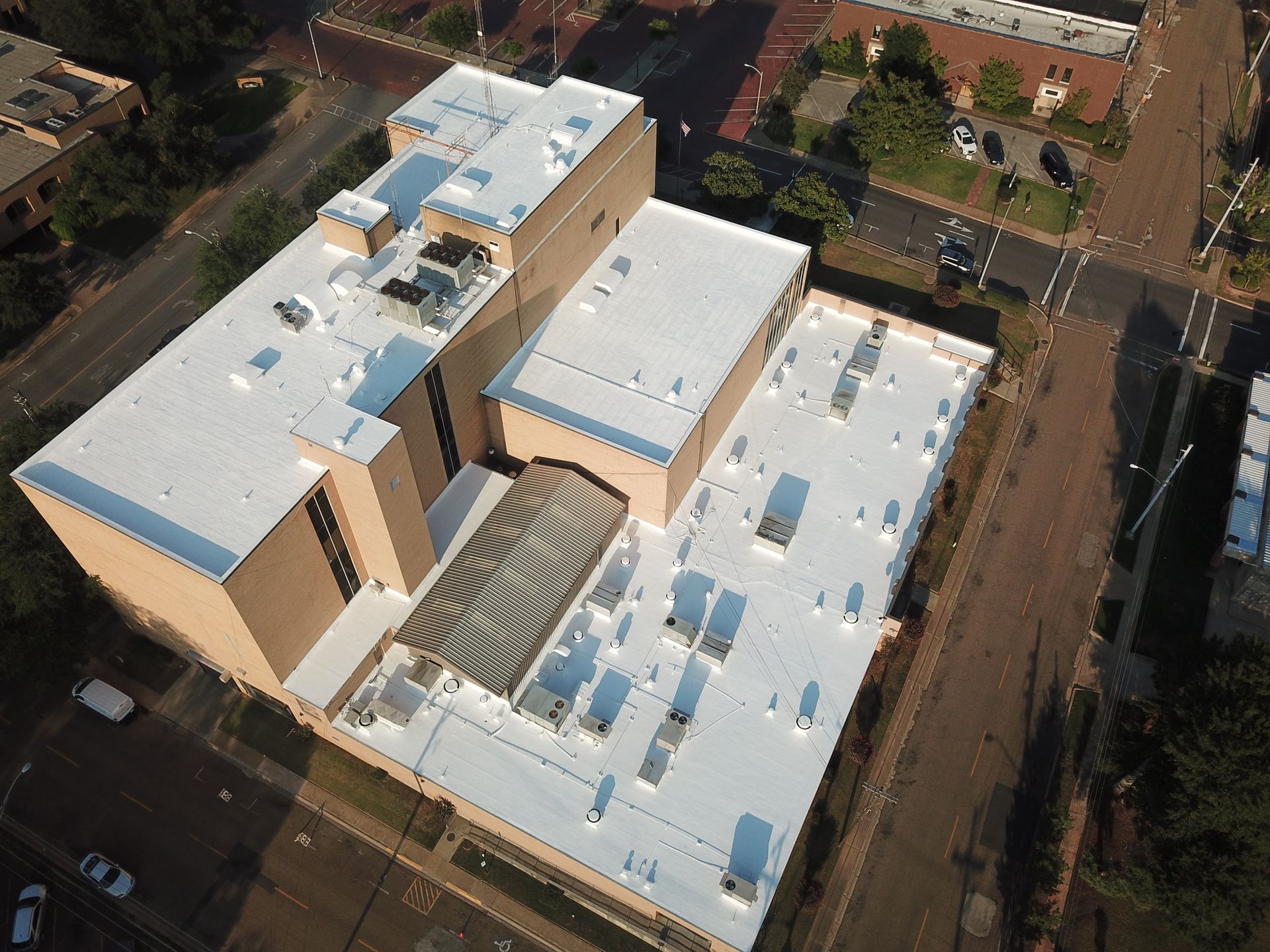 An aerial view of a large building with a white roof