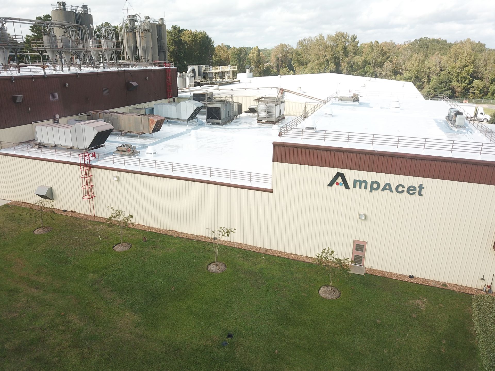 An aerial view of a large building with a white roof