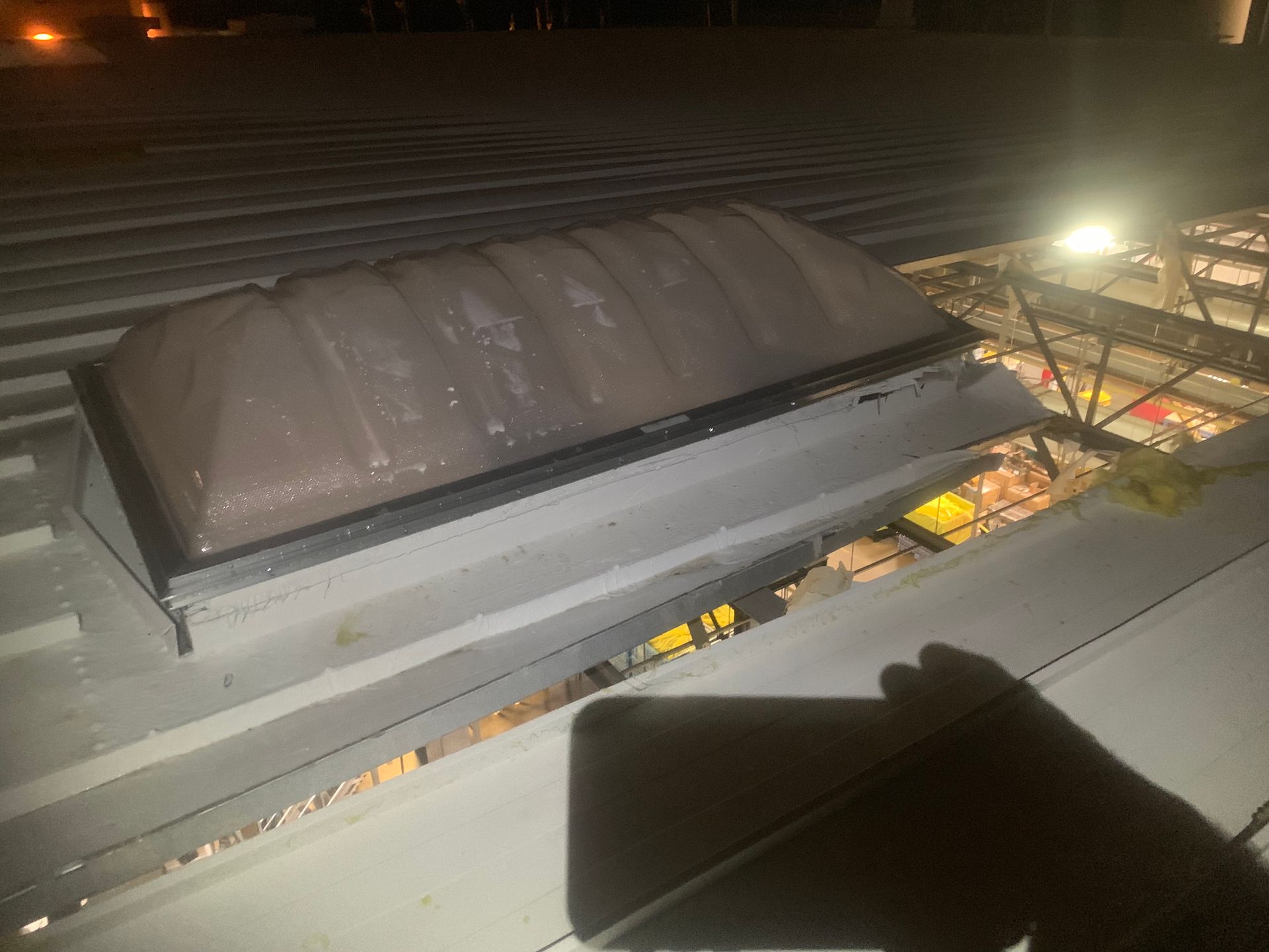 A person is looking down at a roof at night.