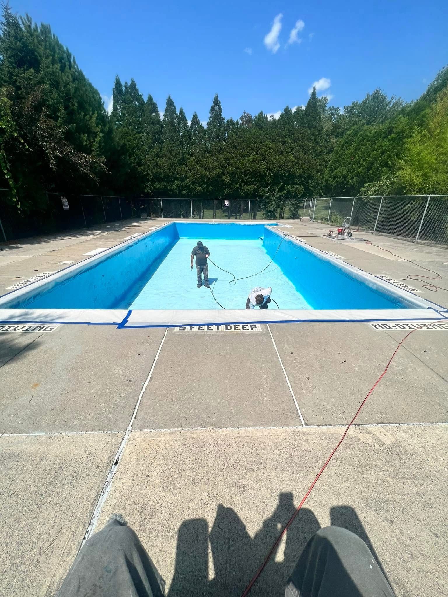 A person is standing in front of an empty swimming pool