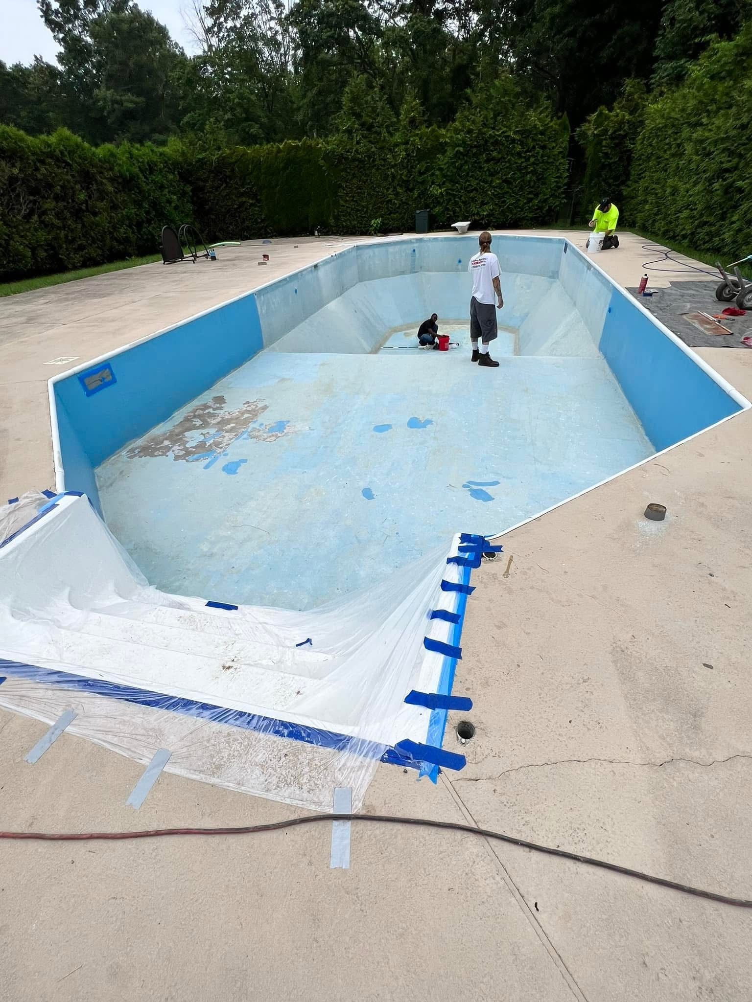 A man is standing in the middle of an empty swimming pool.