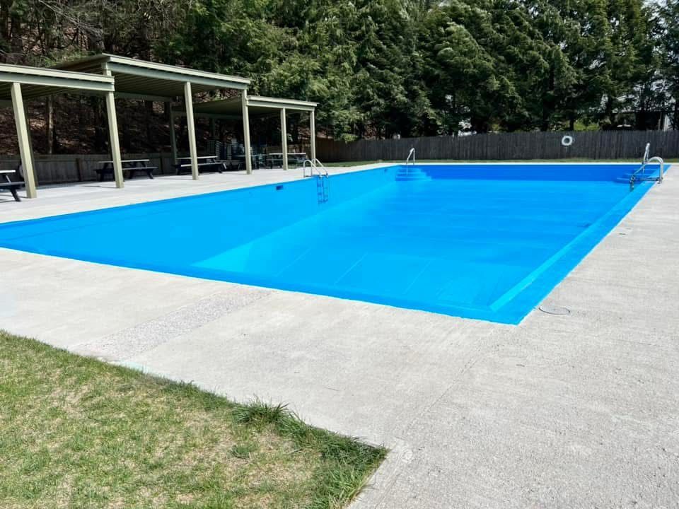 A large blue swimming pool with a life preserver on the side
