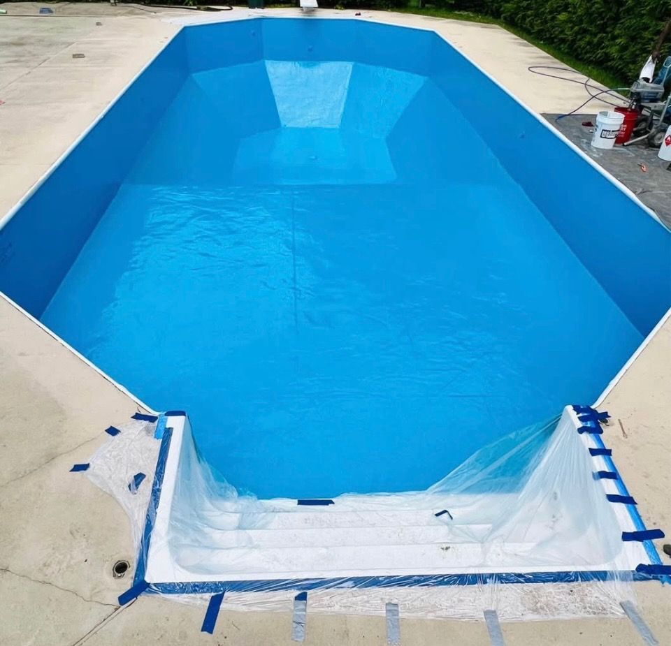 A large swimming pool is being painted blue