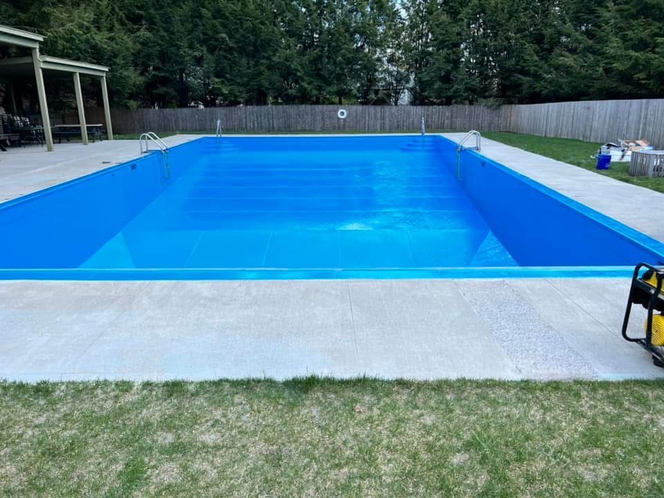 A large blue swimming pool is sitting on top of a lush green lawn.
