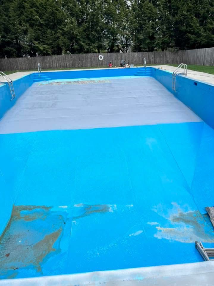 An empty swimming pool with a gray cover on it.