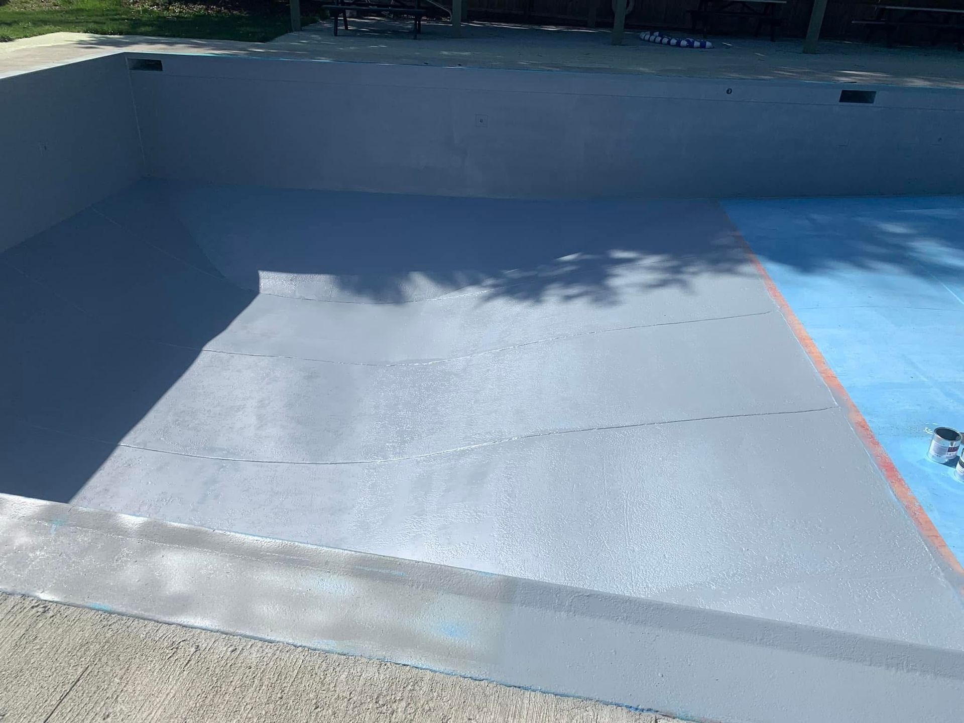 A swimming pool that has been painted grey and blue.