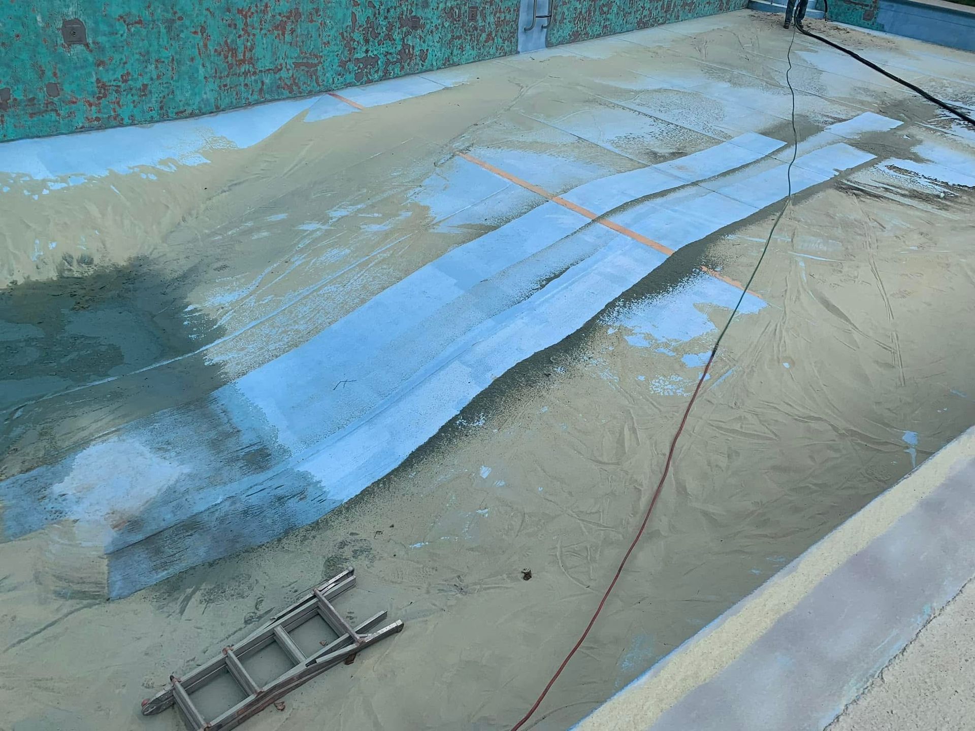 A ladder is sitting on the side of a swimming pool.